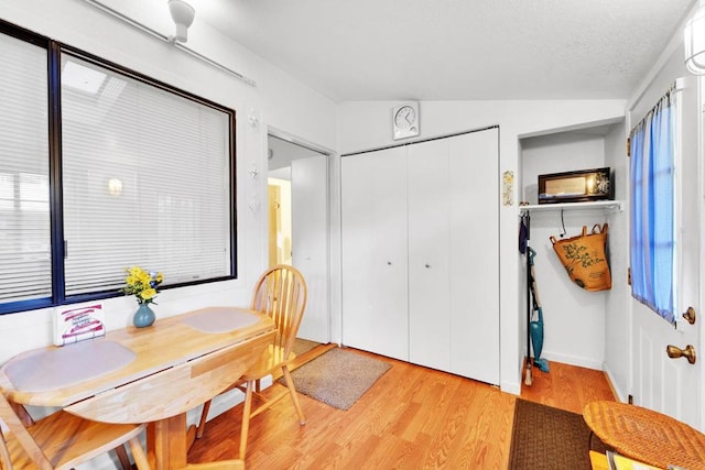 dining area featuring lofted ceiling and light hardwood / wood-style floors