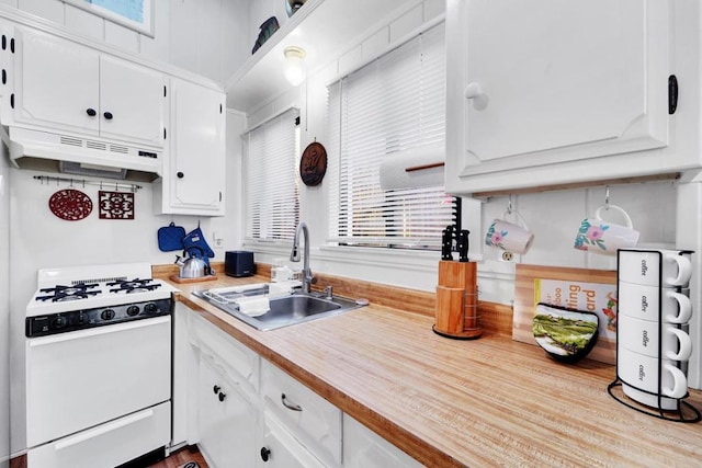 kitchen with white range with gas cooktop, sink, and white cabinets