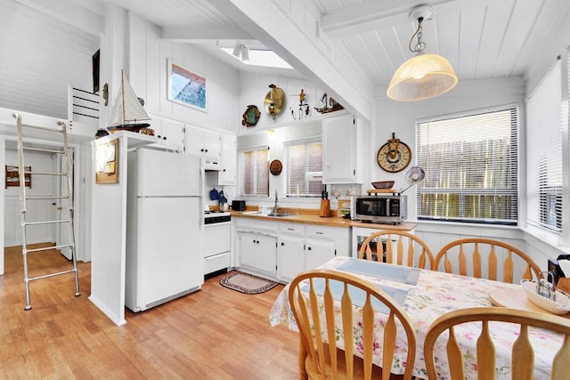 kitchen featuring sink, range, decorative light fixtures, white fridge, and white cabinets