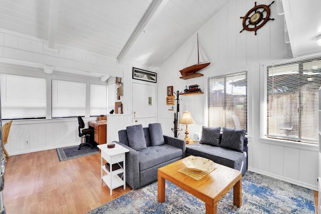 living room featuring lofted ceiling with beams and light hardwood / wood-style floors