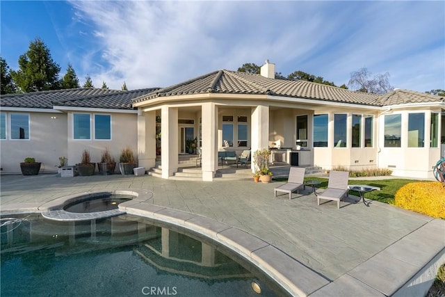 back of property featuring an in ground hot tub, a tile roof, an outdoor pool, and a patio