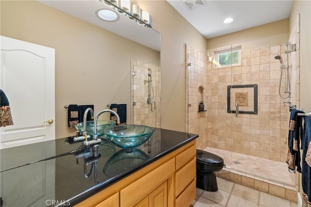 bathroom featuring toilet, visible vents, vanity, tile patterned floors, and a stall shower