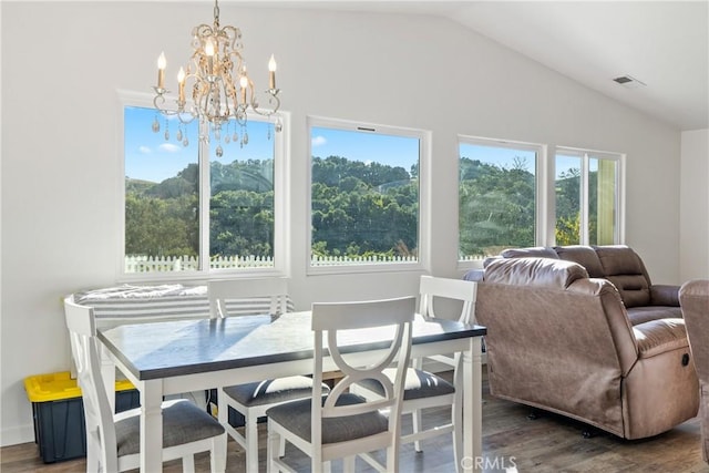 dining space with visible vents, vaulted ceiling, and wood finished floors