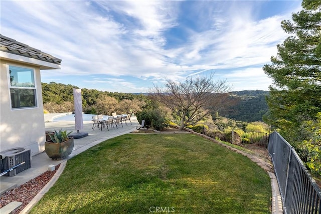 view of yard with a fenced backyard, central AC unit, and a patio