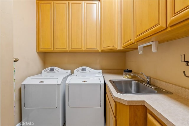 laundry room with cabinet space, washer and clothes dryer, and a sink