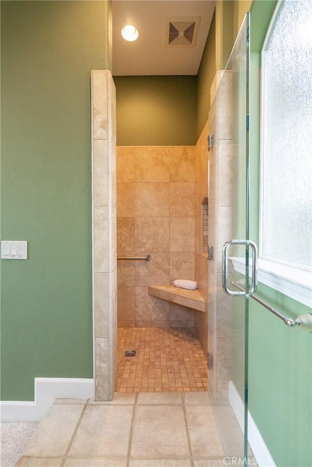 bathroom with a shower stall and visible vents