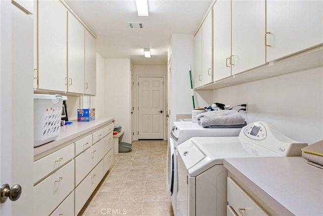 washroom with cabinet space, visible vents, washer and dryer, and light tile patterned flooring