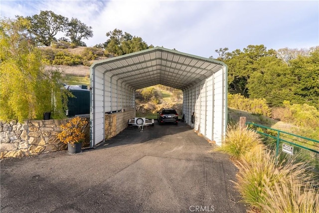 view of parking featuring aphalt driveway and a detached carport