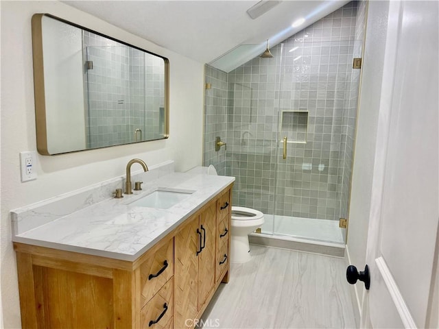 bathroom with vanity, lofted ceiling, toilet, and walk in shower