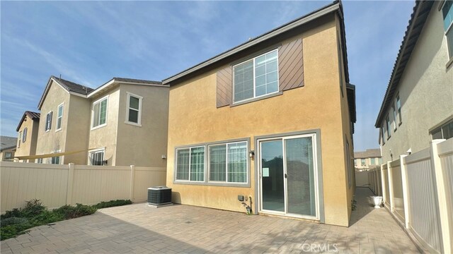 rear view of house featuring a patio area and central AC