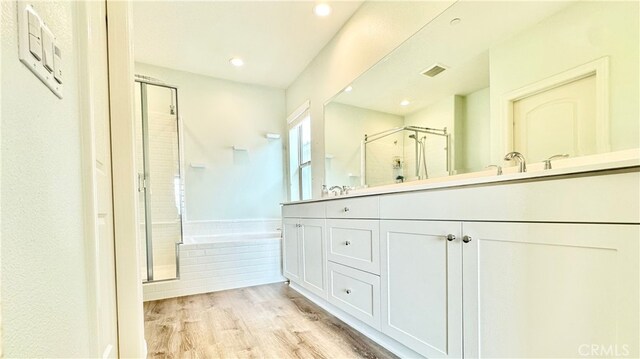 bathroom with vanity, plus walk in shower, and hardwood / wood-style flooring