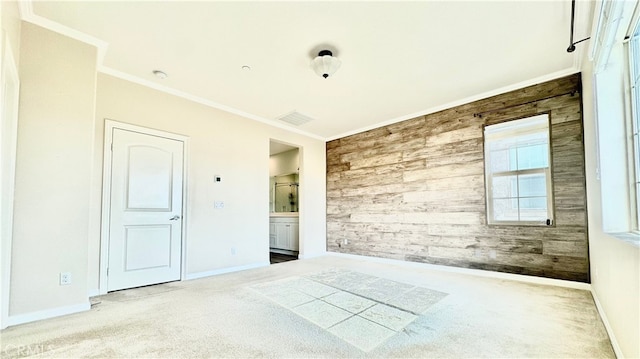 spare room with wood walls, ornamental molding, and carpet flooring