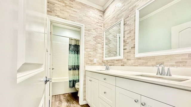 full bathroom with toilet, vanity, shower / bath combo with shower curtain, and ornamental molding