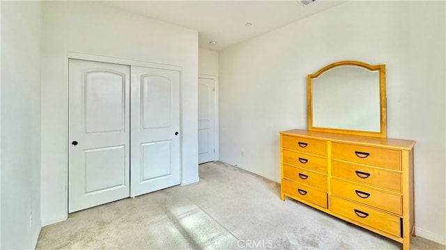 unfurnished bedroom with a closet and light carpet