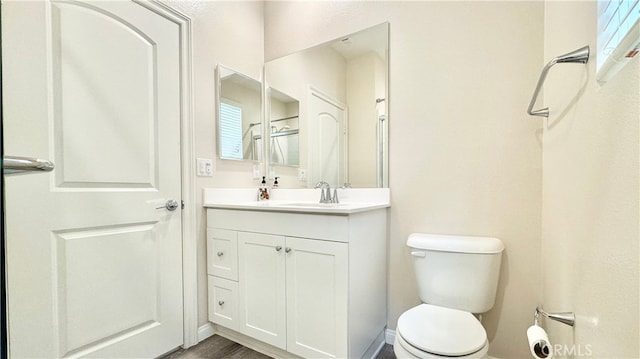 bathroom featuring toilet, wood-type flooring, and vanity