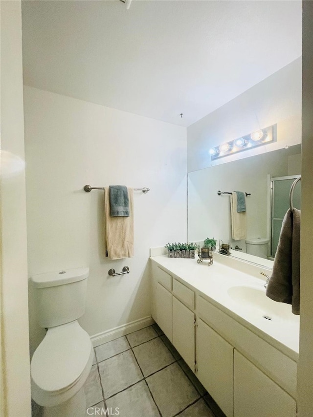 bathroom with tile patterned flooring, vanity, toilet, and a shower with shower door