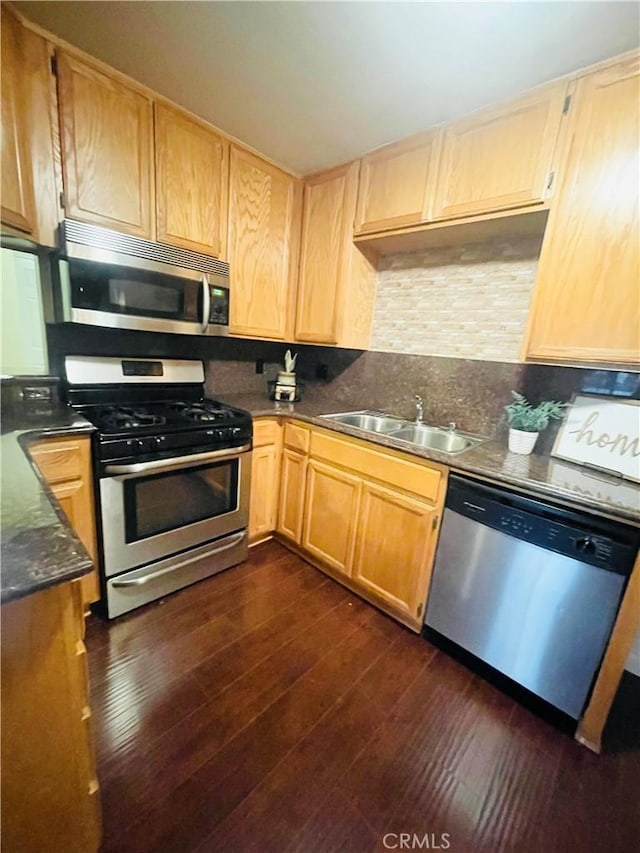 kitchen with decorative backsplash, sink, dark wood-type flooring, and appliances with stainless steel finishes