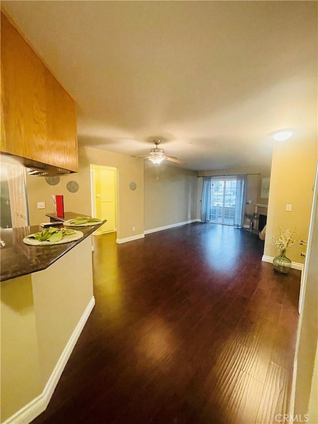 unfurnished living room with ceiling fan and dark hardwood / wood-style flooring