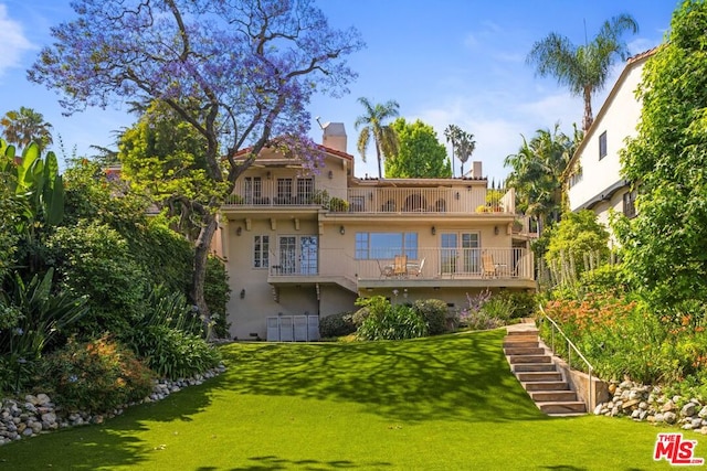 rear view of property with a lawn and a deck