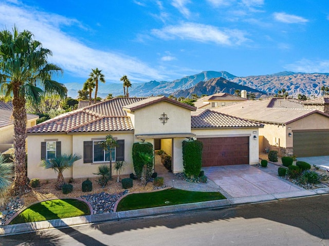 mediterranean / spanish-style house with a garage and a mountain view