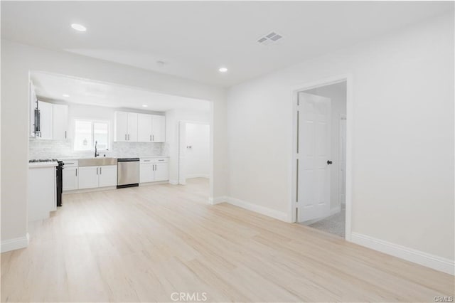 unfurnished living room with light hardwood / wood-style flooring and sink