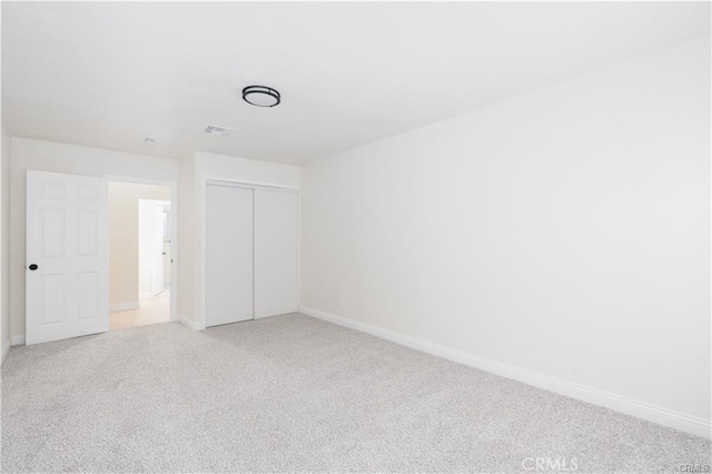 unfurnished bedroom featuring a closet and carpet flooring