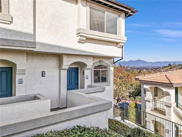 view of exterior entry featuring a mountain view and a balcony