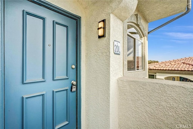 view of exterior entry featuring a balcony