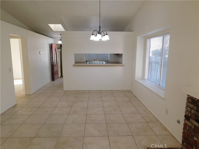 unfurnished dining area with light tile patterned floors, a notable chandelier, and vaulted ceiling