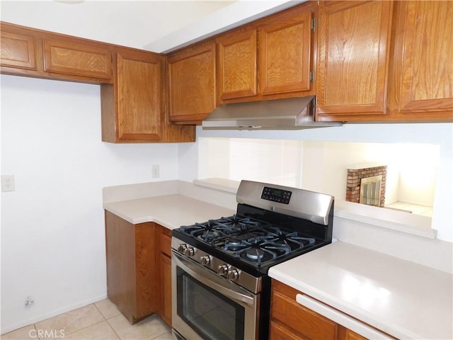 kitchen with stainless steel gas range oven and light tile patterned flooring