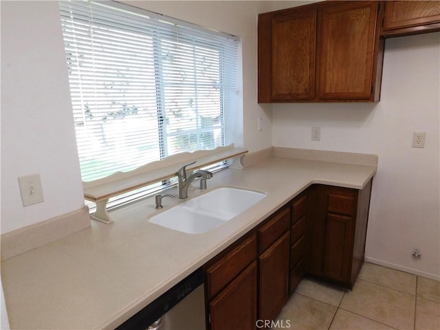 kitchen featuring light tile patterned flooring, stainless steel dishwasher, and sink