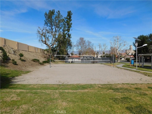 view of community with a lawn and volleyball court