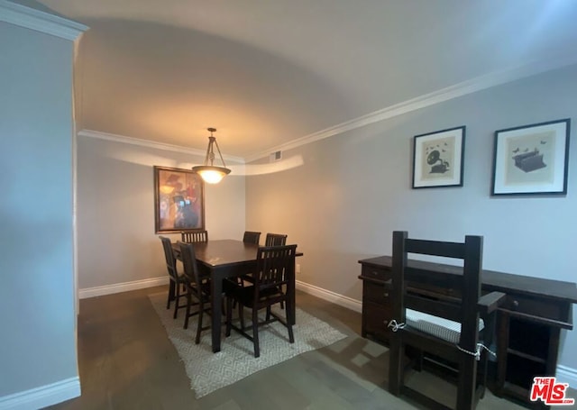 dining area featuring dark wood-type flooring and crown molding