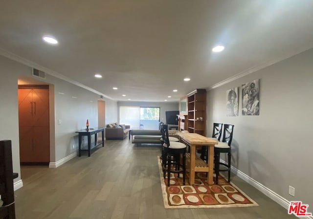 dining space with ornamental molding and hardwood / wood-style floors