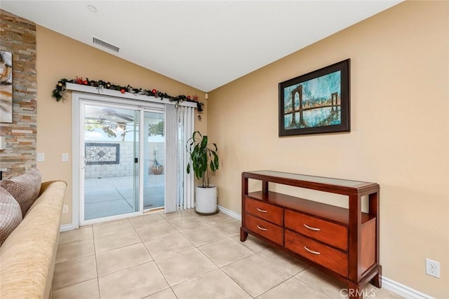 entryway with ceiling fan, light tile patterned floors, and vaulted ceiling