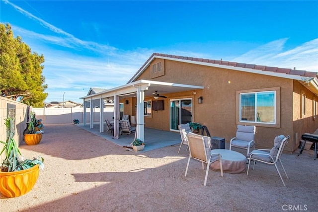 rear view of house with ceiling fan and a patio