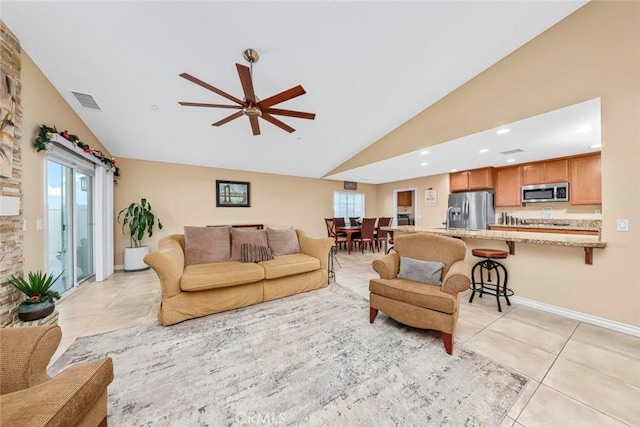 tiled living room featuring ceiling fan, lofted ceiling, and a healthy amount of sunlight