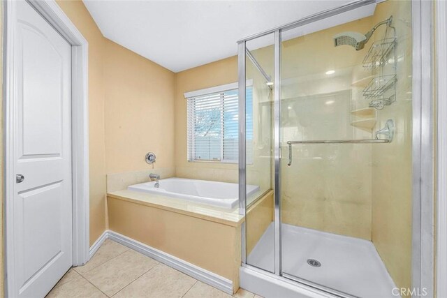 bathroom with independent shower and bath and tile patterned flooring