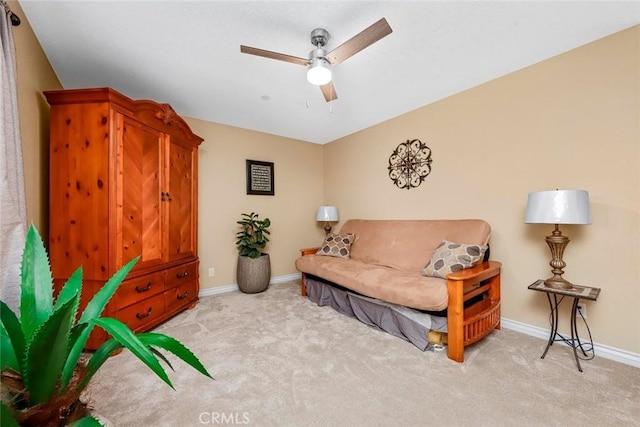 living area with light carpet and ceiling fan