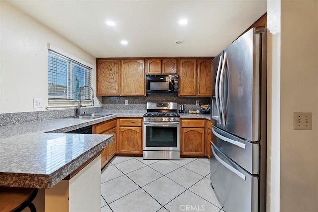 kitchen with tasteful backsplash, light tile patterned floors, sink, kitchen peninsula, and stainless steel appliances