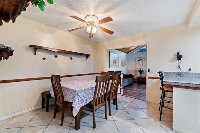 tiled dining room with ceiling fan and a textured ceiling