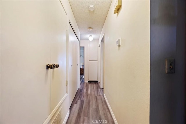 hall featuring hardwood / wood-style flooring and a textured ceiling