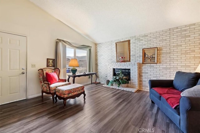 sitting room featuring lofted ceiling, brick wall, a brick fireplace, and dark hardwood / wood-style flooring