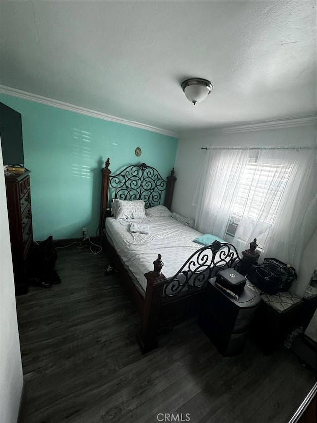 bedroom with dark wood-type flooring and ornamental molding