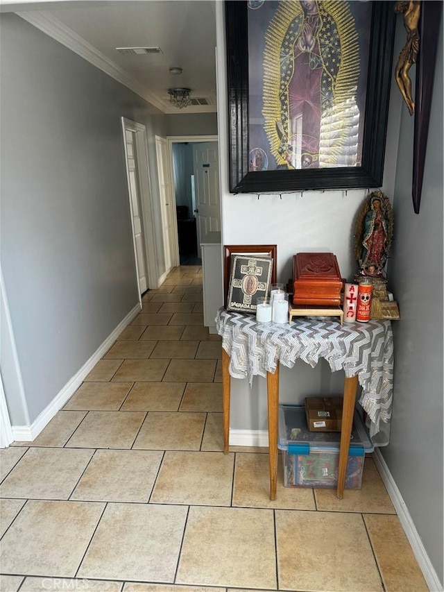 hallway featuring crown molding and light tile patterned floors