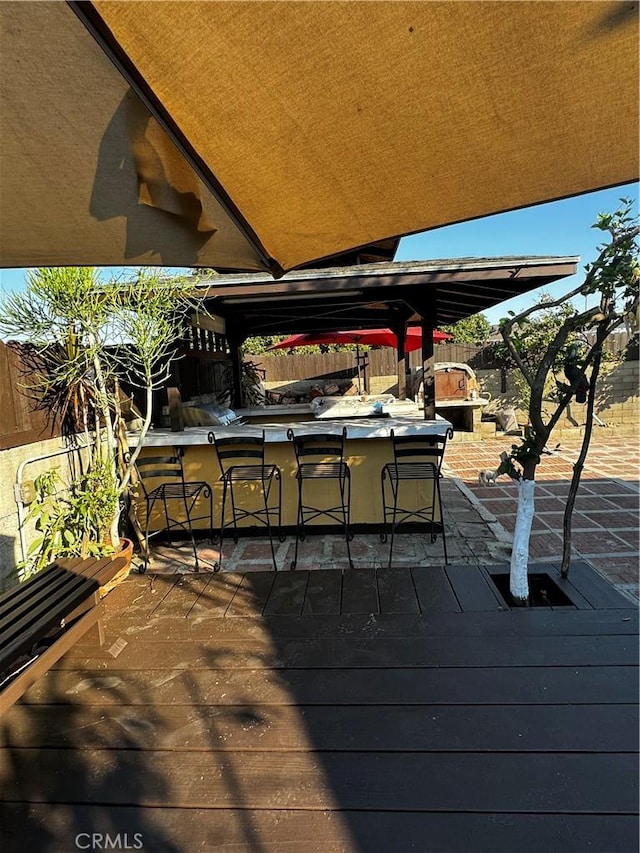 wooden deck featuring exterior kitchen and a bar