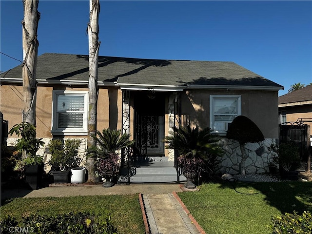 bungalow-style home with a front yard