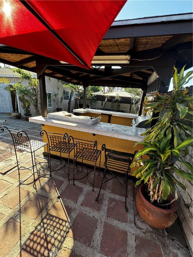 view of patio / terrace featuring an outdoor bar and a gazebo