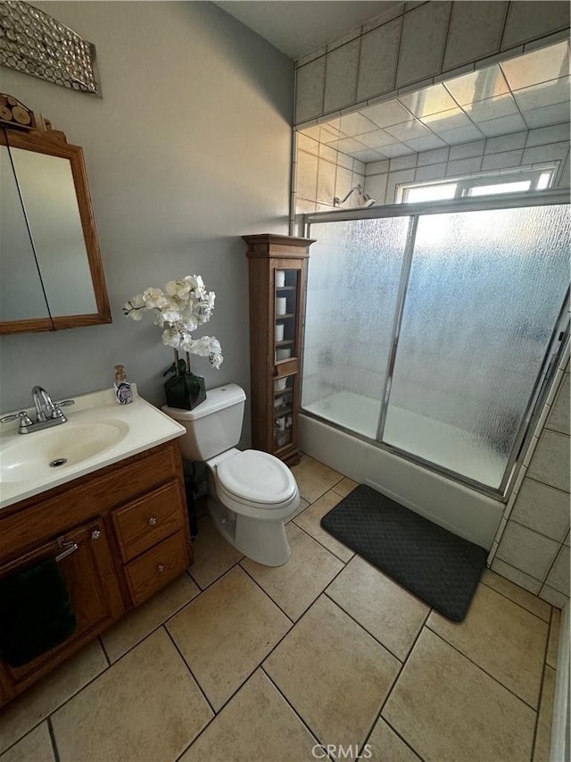 full bathroom with vanity, shower / bath combination with glass door, tile patterned floors, and toilet