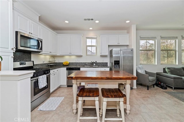 kitchen with appliances with stainless steel finishes, white cabinets, and sink